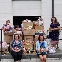 A group of people sitting with donation boxes