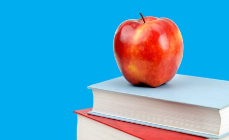 Image containing an apple on top of a stack of books