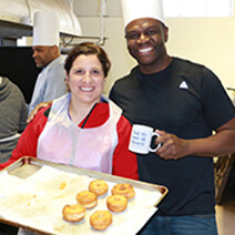 Two people smiling in a kitchen
